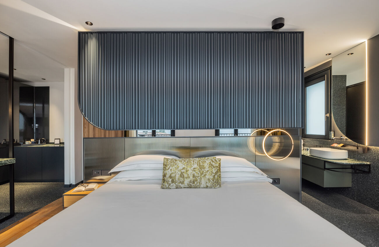 Suite vista lago | Attraverso le grandi vetrate, la luce e i colori del Lago di Garda si riflettono in un’atmosfera senza tempo. Tocchi di blu e verde, un’eleganza discreta votata al comfort, e una vasca da bagno freestanding.