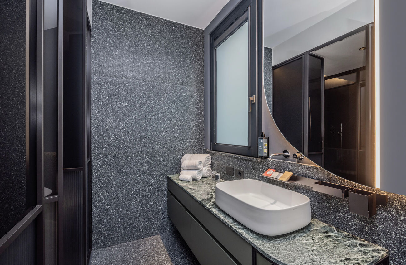 Suite vista lago | Attraverso le grandi vetrate, la luce e i colori del Lago di Garda si riflettono in un’atmosfera senza tempo. Tocchi di blu e verde, un’eleganza discreta votata al comfort, e una vasca da bagno freestanding.