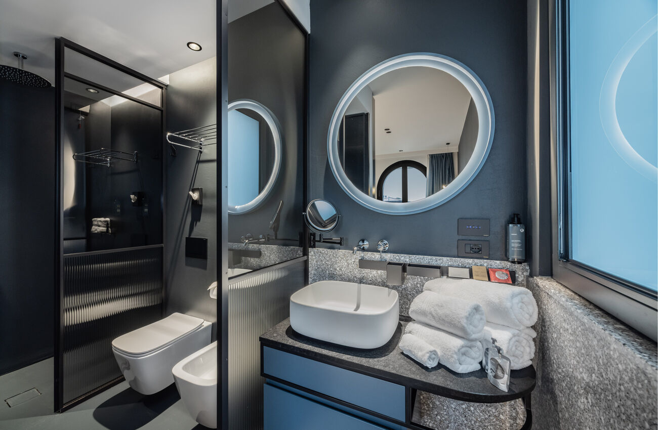Junior suite | Ogni elemento trova il proprio posto in un equilibrio silenzioso tra forme e colori, calibrati per coesistere in armonia. La doccia walk-in si integra nello spazio con una presenza leggera, percettiva.