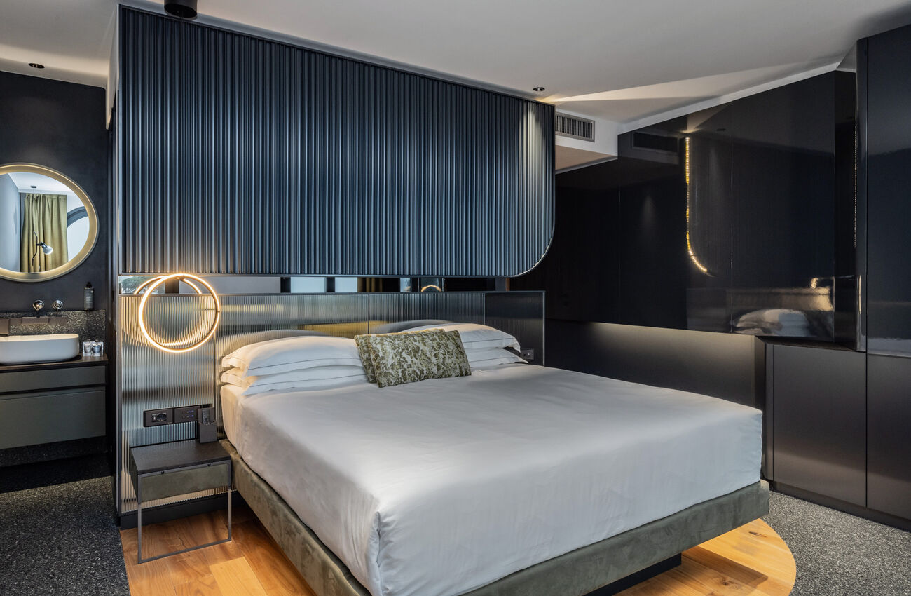 Junior suite vista lago laterale | Un’atmosfera che nasce dall’incontro di volumi e proporzioni, pensati per convivere in equilibrio e continuità. Presenza naturale, la doccia walk-in fluisce nello spazio senza forzature. 